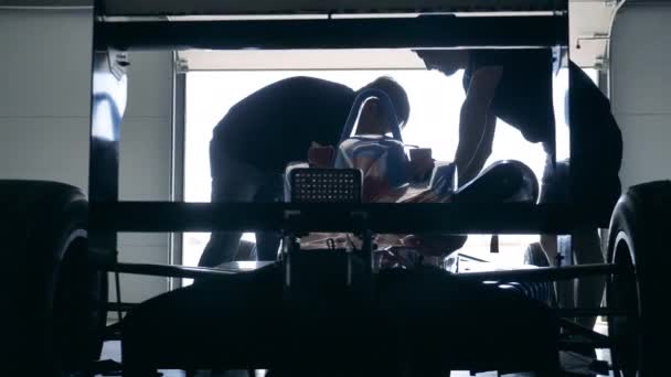 Especialistas en carreras están arreglando un coche deportivo en el garaje — Vídeo de stock