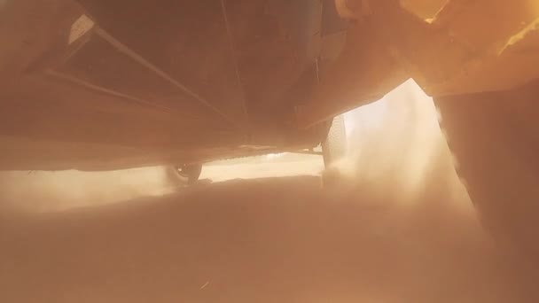 Sport bil filmas underifrån medan racing i moln av damm — Stockvideo