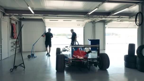 Военнослужащие проверяют гоночный автомобиль в мастерской — стоковое видео