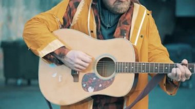 Gitarı çalan bir serserinin ellerinde.