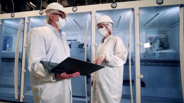 Two engineers in lab coats are discussing modern technologies — Stock Video