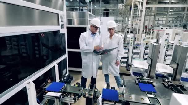 Dois engenheiros estão controlando a fabricação de células solares — Vídeo de Stock