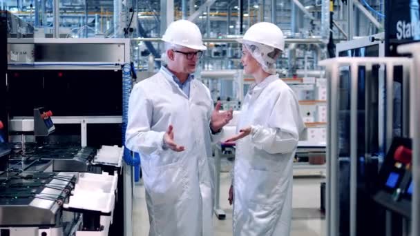Δύο μηχανικοί χαμογελούν ενώ μιλάνε στο εργοστάσιο ηλιακών κυττάρων. — Αρχείο Βίντεο