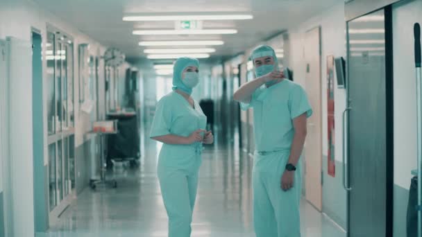 Két sebész beszélget egymással a klinika folyosóján. — Stock videók