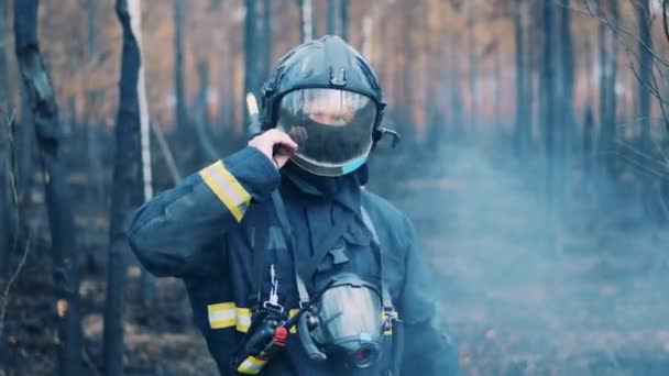 Mężczyzna strażak podnosi daszek z jego kask i rozgląda się wokoło — Wideo stockowe