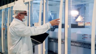 Bilgisayarlı bir çalışan modern üretim sürecini izliyor