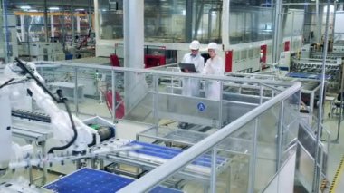 Güneş enerjisi üretimi iki çalışan tarafından gözlemleniyor