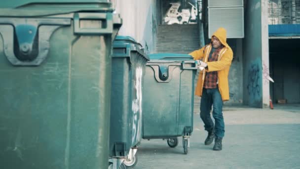 Ein Landstreicher wühlt in den Mülltonnen — Stockvideo