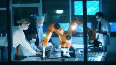 Robot mühendisleri bilişim laboratuarında yüz maskesi takıyor.