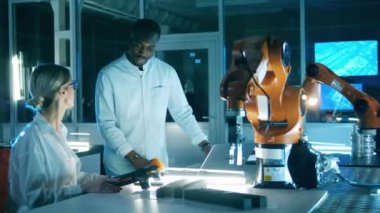 Mühendislik meslektaşları robot laboratuvarında konuşuyorlar.