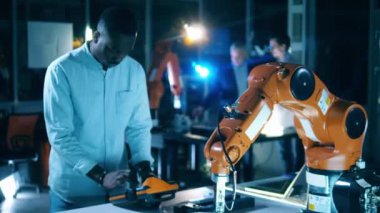 Laboratuvar robotu Afro-Amerikan bir mühendis tarafından çalıştırılıyor.