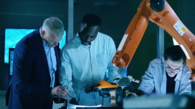 Bilişim mühendisleri laboratuvarda bir robot mekanizmasını inceliyor.