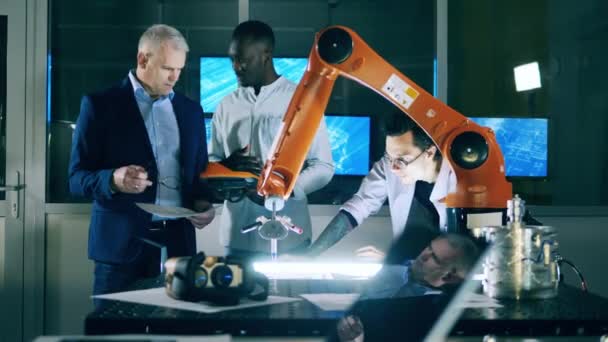 Robottekniker studerar cybernetiska enheter — Stockvideo