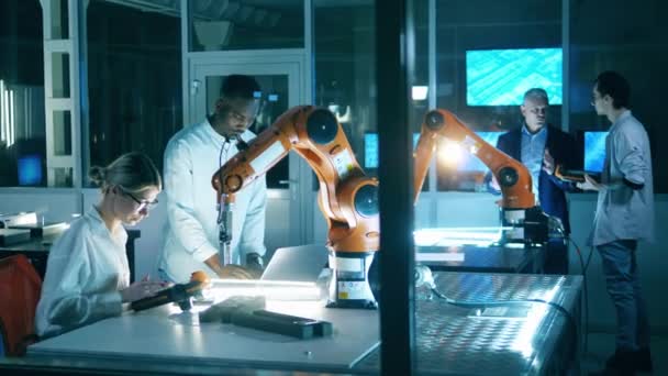 IT-Labor mit einer Gruppe von Ingenieuren, die Roboter untersuchen — Stockvideo