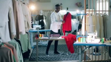 African-american tailor is fixing fabric on the dummy