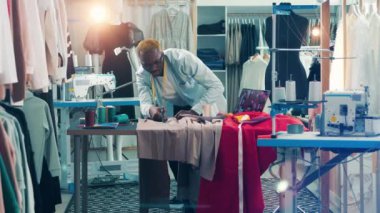 African tailor is cutting out a piece of fabric