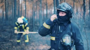 Firefighter is talking over the radio while working in the fire zone