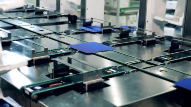 Solar cells are getting relocated and distributed by a robotic conveyor