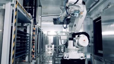 Industrial robot is relocating solar panels between the shelves