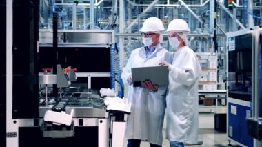 Two plant inspectors are observing modern equipment at work