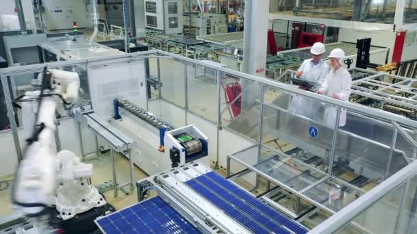 Proses produksi panel surya dengan dua inspektur mengamatinya — Stok Video