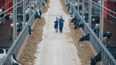 Animal farm with two experts walking along it