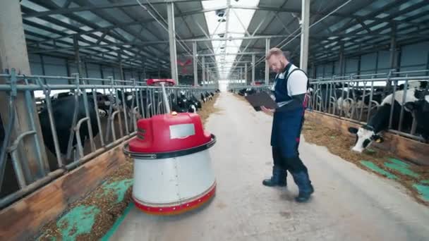 Allevatore sta gestendo un robot agricolo tramite laptop — Video Stock