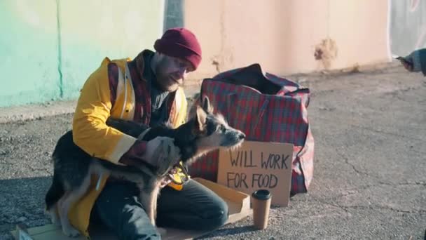 Un mendigo y un perro callejero reciben dinero de extraños. — Vídeos de Stock