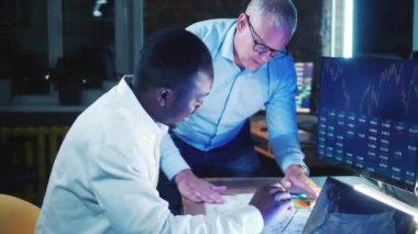 İki borsacı bilgisayar verilerini tartışıyor. Yatırım, finans, iş konsepti.