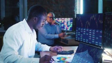 Afrikalı borsacı masasında hesaplamalar yapıyor. İş, finans, piyasa ticaret kavramı.