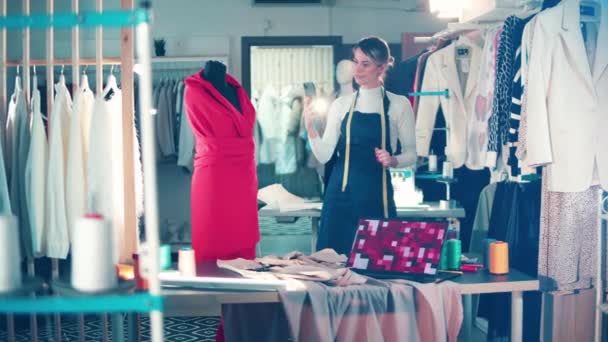 Una costurera está tomando una foto de un maniquí con un vestido. — Vídeos de Stock