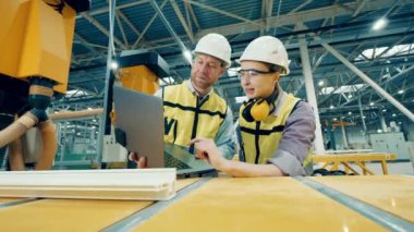 İki fabrika işçisi fiberglas çerçeveyi inceliyor. Fabrika işçileri, endüstriyel, teknoloji, üretim kavramı.