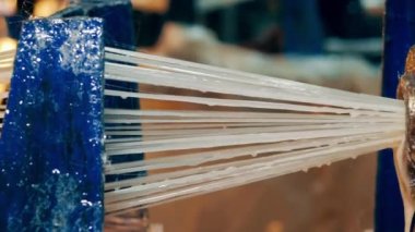 Fiberglas dizileri yuvarlanan bir tüpe çekiliyor.