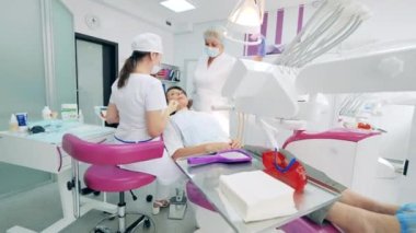 Dişçiler klinikte bir hastayı tedavi ediyor.