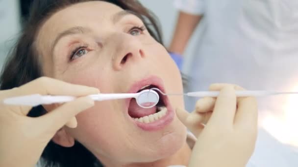Una mujer se va a hacer un chequeo dental. — Vídeo de stock