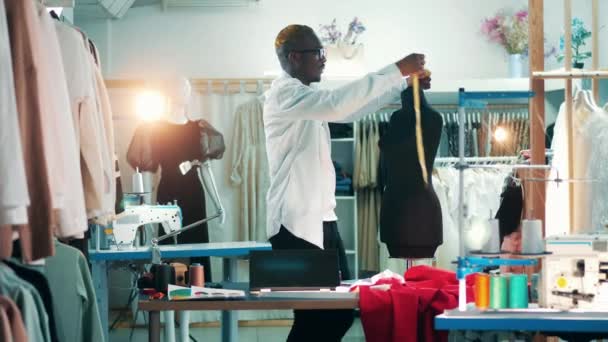 Un designer africain mesure un mannequin en studio — Video