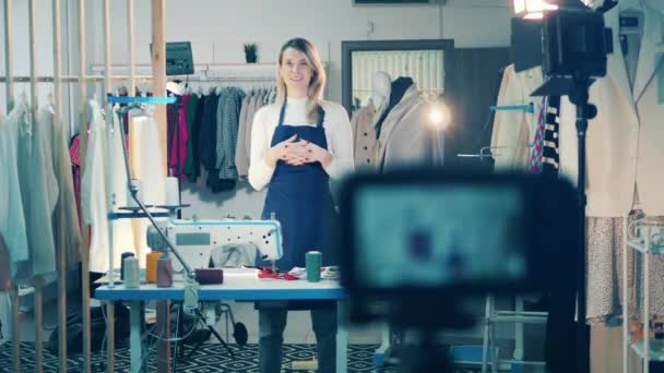 Женщина-портниха снимает видеоблог в своей мастерской — стоковое видео
