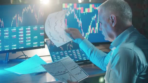 Hombre comerciante está observando informes con datos del mercado de valores — Vídeos de Stock