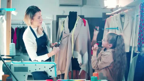 Krawcowa i dziewczyna pracują razem z tkaniną — Wideo stockowe