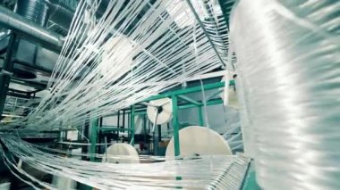 Strings of fiberglass are getting wound into rolls