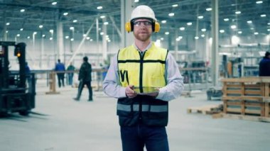 Factory premises with a male specialist in protection wear