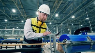 Dizüstü bilgisayarı olan bir erkek uzman fiberglas çerçeveyi inceliyor.