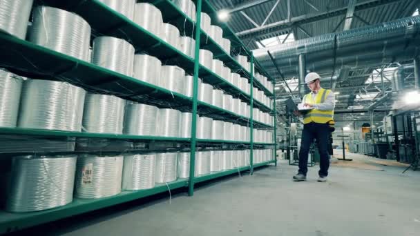 Pracovník továrny provádí inventuru rolí ze sklolaminátu — Stock video