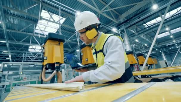 Fiberglass frame is getting inspected by a factory worker — Vídeo de stock