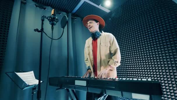En man sjunger och spelar piano i inspelningsstudion — Stockvideo