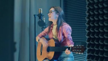 A singing lady is getting recorded in the studio