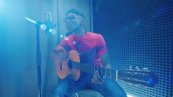Young african man is playing the guitar in the recording studio — Stockvideo