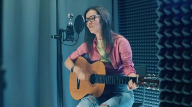 Recording studio with a lady playing the guitar. 4K