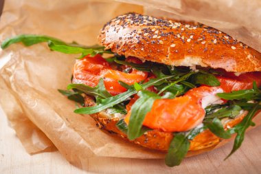 Simit krem peynir, somon füme ve kahverengi kağıt torba roka salatası ile. Yakın çekim