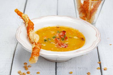 Bezelye çorbası pastırma ile ahşap arka plan üzerinde grisini ile devam eder. Yakın çekim